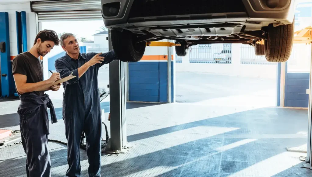 Deux garagistes scrutant un véhicule